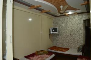 KachāhriHotel Deluxe的客房设有两张床和一台墙上的电视。