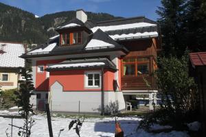 巴德加斯坦斯努克别墅 - 红色度假屋的屋顶上积雪的房子