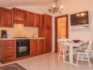 皮内兹齐Apartment Dilly - KRK117 by Interhome的一间带木制橱柜和桌子的厨房以及一间用餐室