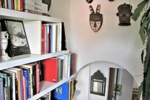 佩鲁贾Casa con vista fantastica的书架,墙上挂着书和时钟