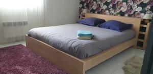 武夫赖Au fil de la Loire的一间卧室配有一张带紫色枕头的大床