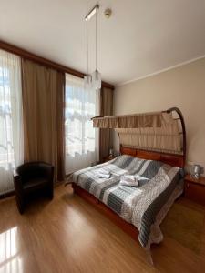 格涅兹诺Hotel City的一间卧室配有一张床和一把椅子
