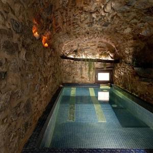 GratteriWUNDERGARTEN Dimora dei Frati的石墙洞内的游泳池