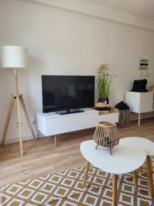 普拉加德阿罗somtresapartament的客厅配有大电视和白色桌子
