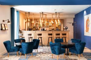 卡尔卡松SOWELL HOTELS Les Chevaliers的一间酒吧,房间内设有蓝色的椅子和桌子
