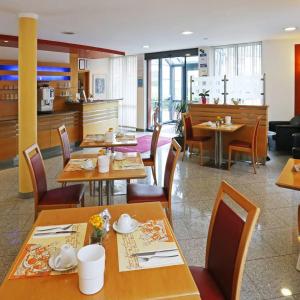 慕尼黑Hotel Graf Lehndorff zur Messe的一间带木桌椅的餐厅和一间厨房