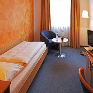 慕尼黑Hotel Graf Lehndorff zur Messe的酒店客房配有一张床铺和一张桌子。