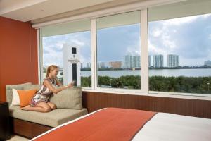 坎昆InterContinental Presidente Cancun Resort的坐在窗户房间里椅子上的女人