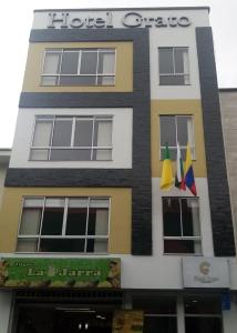 马尼萨莱斯Hotel Grato Manizales的悬挂在外边的有旗帜的建筑