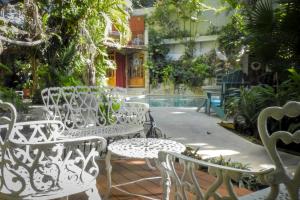 坎昆艾尔雷伊德尔加勒比经济型酒店的一组坐在泳池旁的白色椅子