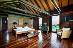 甘格西Gangehi Island Resort & Spa的铺有木地板的客房内设有一间卧室,配有一张床。