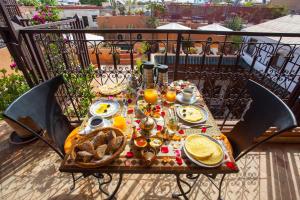 马拉喀什梅尔霍恩摩洛哥传统庭院旅馆及Spa的阳台上的桌子上摆放着食物和饮料
