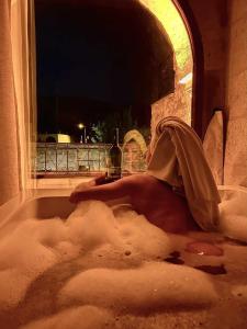 格雷梅天使洞穴套房酒店的躺在雪覆盖的浴缸里的人