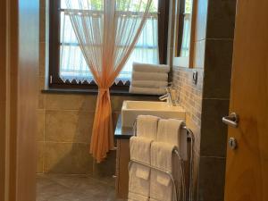 布雷斯Agriturismo La Canonica的一间带水槽的浴室和一个带毛巾的窗户。
