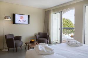 塔维拉OZADI塔维拉酒店 的酒店客房,配有一张床和两把椅子