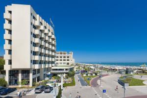 里乔内Hotel Baltic Riccione-Fronte Mare的海滩旁的白色大建筑
