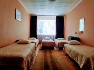 Uulu白屋旅舍的带四张床和窗户的客房
