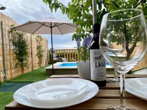 马拉加Suite Apto de Invitados- Heated Pool-Piscina Climatizada- Montes de Málaga的一张桌子,上面放着盘子和葡萄酒杯