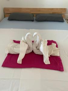 奥米沙利Apartments Michael & Petra , Omisalj, Insel Krk, Kroatien的床上有两条毛巾天鹅,心中