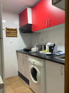 阿尔巴塞特Apartamento de 1 dormitorio en buena ubicación的厨房配有洗衣机和红色橱柜。