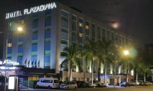 瓜达拉哈拉戴安娜广场酒店的夜间酒店,停车场内有车辆停放