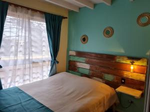 阿尔加罗沃Cabañas Costa Norte的一间卧室配有一张带木制床头板的床和窗户。