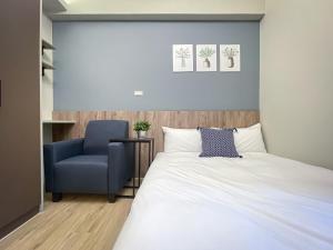 台中市想想旅居 Allegro Hostel的一间卧室配有一张床和一张蓝色椅子
