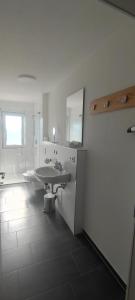 腓特烈港Ferienwohnung Alvino的白色的浴室设有水槽和镜子