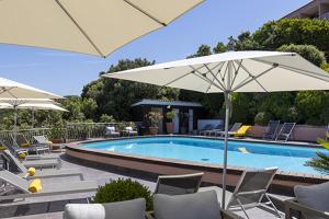 皮亚纳卡波罗索酒店的游泳池旁设有椅子和遮阳伞