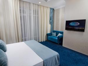 格连吉克Hotel Orion的配有一张床和一把椅子的酒店客房