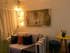 萨尔瓦多Maravilhoso apartamento 2 quartos vista mar no Ondina Apart的客厅配有沙发和墙上的绘画