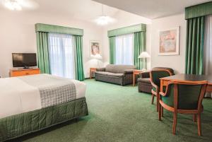印第安纳波利斯印第安纳波利斯机场莱胡斯特拉昆塔酒店的酒店客房带一张床、一张桌子和椅子