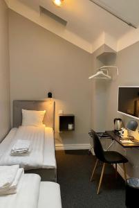 斯德哥尔摩Unique Hotel Jungfrugatan的配有一张床和一张书桌的酒店客房