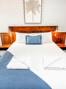 巴加拉Pacific Sun Bargara的一张带两个蓝色枕头的大白色床
