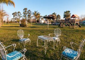 科隆Complejo Paradise的一组椅子、一张桌子和一个游乐场