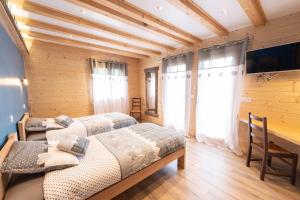 阿尔维厄LE CHALET BAZAN的配有木墙和窗户的客房内的两张床