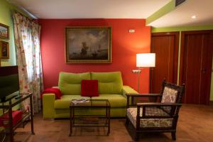 安度亚尔Palacio Sirvente Mieres - PARKING GRATUITO的客厅设有绿色沙发和红色墙壁。