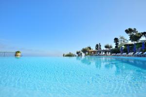 阿纳卡普里西泽奥古斯都酒店的一座蓝色海水和椅子的大型游泳池