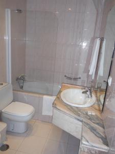 旧阿尔贝加里亚Hotel Alameda的浴室配有盥洗盆、卫生间和浴缸。