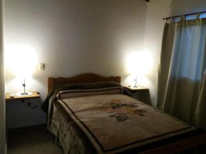 坦迪尔Deptos del sur的一间卧室配有一张床,两盏台灯放在两张桌子上