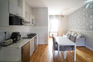 DubíSpa Apartments Theresia的厨房配有桌子和白色的桌椅