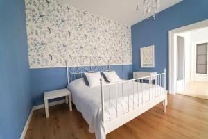 DubíSpa Apartments Theresia的蓝色的卧室设有白色的床和蓝色的墙壁