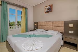 瓦西里科斯普拉卡海滩度假酒店的卧室配有白色大床和白色遮阳伞
