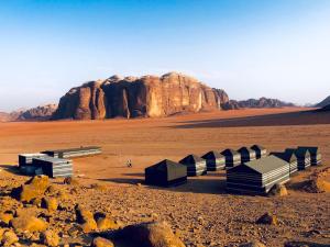 瓦迪拉姆Wadi Rum Cave Camp &Jeep Tour的沙漠中间的一群建筑物