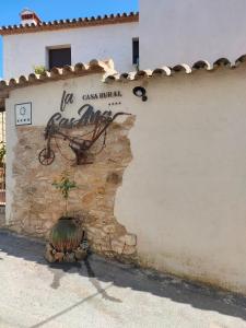 Fuente del ArcoCasa Rural La CasAna的建筑物一侧有标志的墙