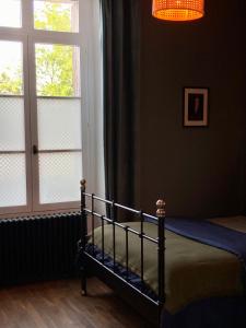 普罗万Logis « Henriette » • Maison du XVe siècle的一间卧室设有一张床、一个窗户和一个吊灯。