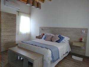 图努扬CAYE Guest House的卧室配有带蓝色枕头的大型白色床