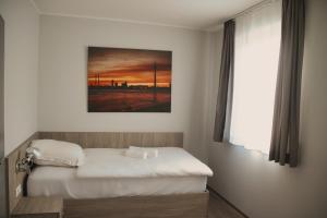 JüchenLandgasthof Kelzenberg的卧室配有一张床,墙上挂有绘画作品