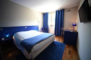 盖布维莱尔杜拉克酒店的一间卧室配有一张带蓝色窗帘的床和电视。