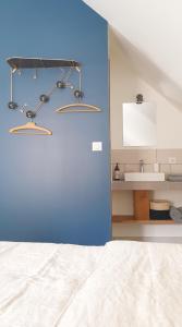 Coulanges-la-VineuseLa Croix au Maitre的一间卧室设有蓝色的墙壁、一张床和一个水槽